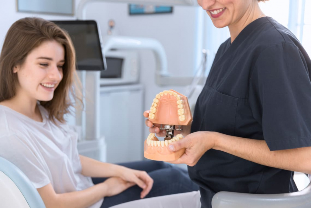 close-up-dentist-showing-teeth-model-smiling-patient (1).jpg